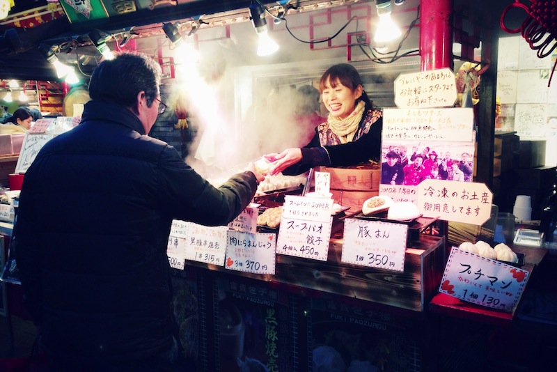 Dependienta atendiendo a un cliente en el barrio chino de Yokohama