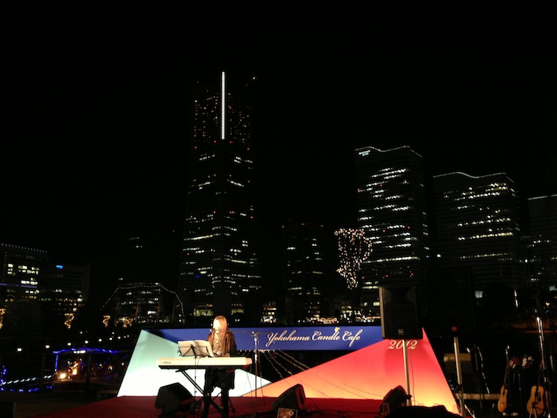 Chica tocando el piano frente a la torre Landmark